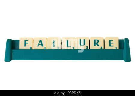 Gioco Scrabble lettera di piastrelle con valore di punteggio su un supporto formante la parola "fallimento". Isolato su sfondo bianco. Foto Stock