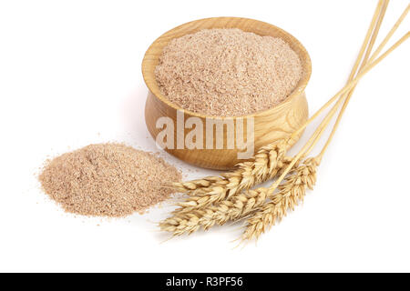 Pila di crusca di frumento nella ciotola di legno con orecchie isolati su sfondo bianco Foto Stock