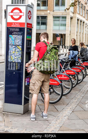 City of London England,UK Santander Cycles,noleggio biciclette pubblico schema,bike sharing,Boris Bikes,pay station,man men maschio,zaino,transazione a pagamento,UK Foto Stock