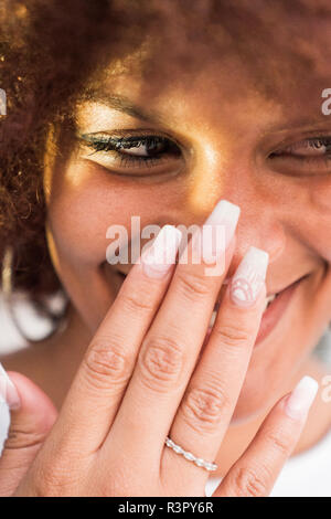 Ritratto di ridere giovane donna con unghie artificiali Foto Stock