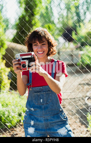 Ritratto di donna sorridente con fotocamera istantanea Foto Stock