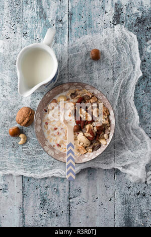 Ciotola di muesli con dadi e una caraffa di latte Foto Stock