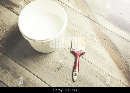 Spazzola di vernice sul possibile giacente sul tavolo di legno Foto Stock