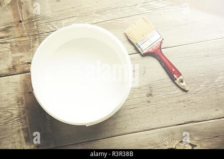Spazzola di vernice sul possibile giacente sul tavolo di legno Foto Stock