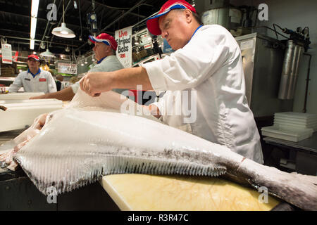 Lavoratori a Wholey il mercato in Pittsburgh, Pennsylvania slice e filetto di pesce di grandi dimensioni per la preparazione per la vendita. Foto Stock