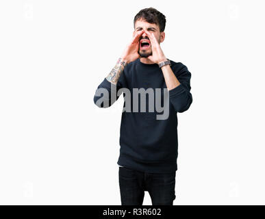 Giovane uomo bello su isolati che urlava arrabbiato ad alto volume con Mani sulla bocca Foto Stock