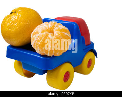 Carrello giocattolo auto pieno con giallo arancione disperse mandarini tangerini. back auto parte shot isolato su sfondo bianco Foto Stock