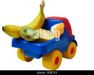 Banana, kiwi, mandarine, limone - alcuni frutti esotici sul giocattolo auto carrello. ogranic Consegna del cibo il concetto di servizio. da dietro la schiena shot isolato su bianco b Foto Stock