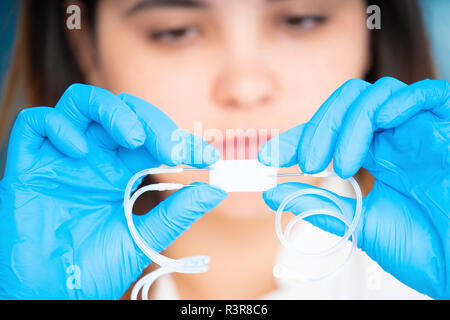 Tecnico che lavora con un laboratorio microfluidico su un chip dispositivo. Foto Stock