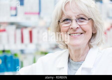 Ritratto di sorridente femmina senior il farmacista in piedi in farmacia. Foto Stock