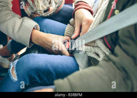 Close-up di donna sicurezza di fissaggio della cintura di sicurezza della ragazza seduta in una macchina Foto Stock