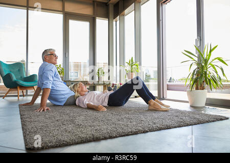 Coppia matura in un momento di relax a casa guardando fuori della finestra Foto Stock