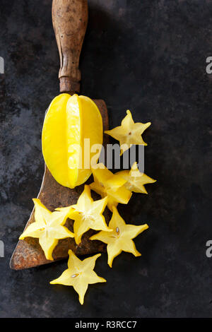 Starfruit affettato su un vecchio cleaver Foto Stock