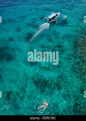Indonesia, Bali, veduta aerea della laguna blu, snorkeler e banca barca Foto Stock