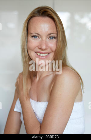 Ritratto di una donna sorridente, avvolto in asciugamano Foto Stock