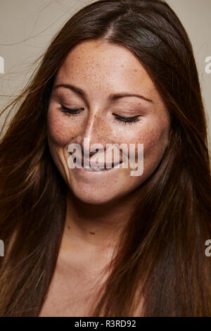 Ritratto di freckled giovane donna che guarda in basso Foto Stock