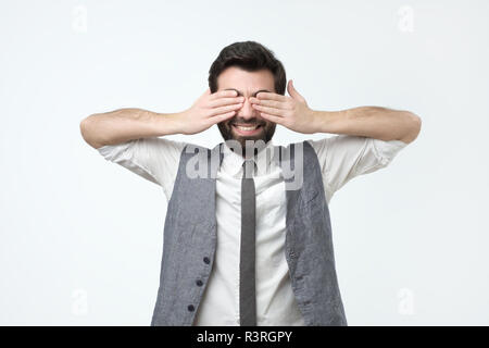 Sorridente uomo ispanico con la barba chiudendo gli occhi Foto Stock