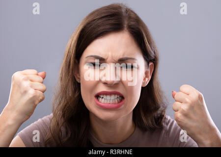 Ritratto di un giovane arrabbiato donna Clenching i suoi denti Foto Stock