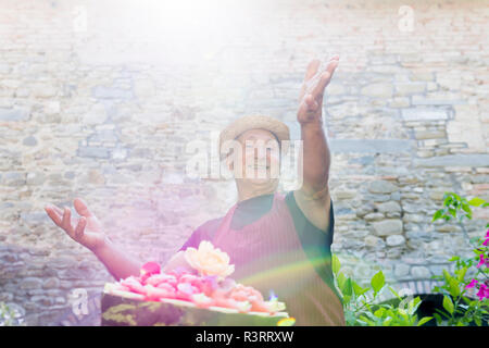 Ritratto di sorridere senior uomo presentando un cocomero decorate in controluce Foto Stock