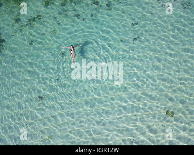 Indonesia, Bali, Melasti, vista aerea del Karma Kandara beach, donna galleggiante sull'acqua Foto Stock