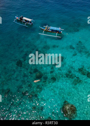 Indonesia, Bali, veduta aerea della laguna blu, snorkeler e banca barche Foto Stock