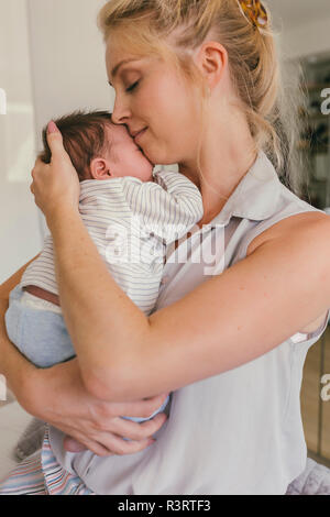 Madre felice tiene il suo bambino vicino alla sua spalla Foto Stock