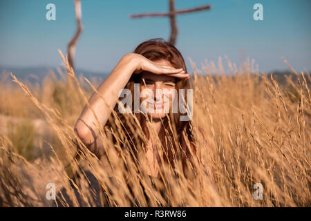 Giovane donna in campagna guardando fuori Foto Stock