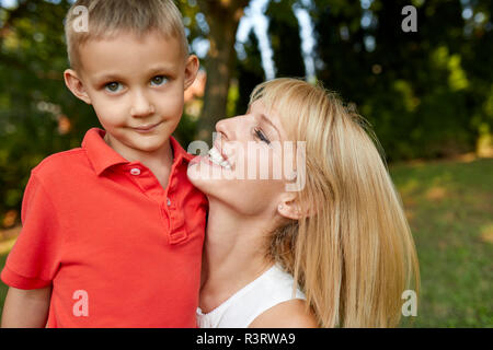 Felice madre che porta il suo figlio in giardino Foto Stock