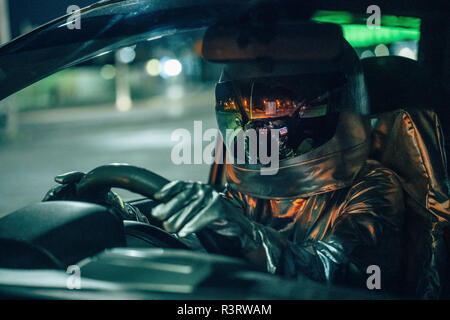 Spaceman guida auto di notte Foto Stock