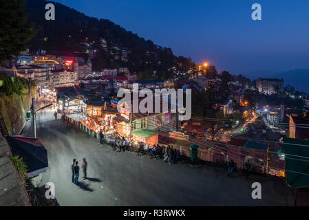 Un gruppo di tre persone fermato per avere una chat sulla trafficata strada Mall in Shimla di notte, Himachal Pradesh, India Foto Stock