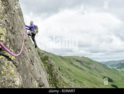 Regno Unito, Lake District, Longsleddale valley, Buckbarrow roccioso, uomo di arrampicata in parete di roccia Foto Stock