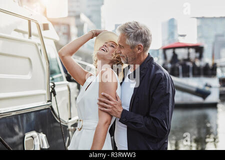 Uomo vecchio e giovane donna a marina accanto a uno yacht Foto Stock