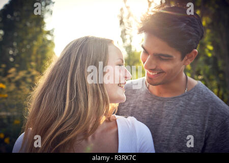 Felice coppia giovane flirtare in un parco in estate Foto Stock