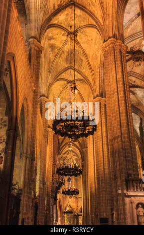 Dark chiostro gotico ornato di lampadari di metallo nella Cattedrale della Santa Croce e di Santa Eulalia, o la Cattedrale di Barcellona in Barcellona, Spagna Foto Stock