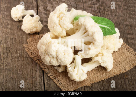 Fresche biologiche il cavolfiore tagliato in piccoli pezzi su sfondo rustico Foto Stock