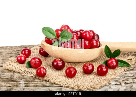 Mirtillo rosso con foglie di cucchiaio di legno sul vecchio tavolo in legno con sfondo bianco Foto Stock