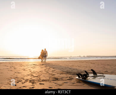 Coppia romantica facendo una passeggiata sulla spiaggia al tramonto Foto Stock