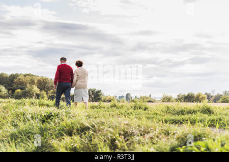 Coppia senior in una passeggiata nel paesaggio rurale Foto Stock