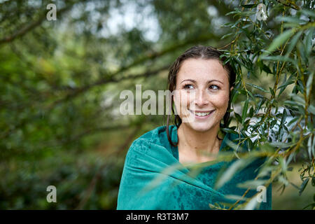 Ritratto di freckled giovane donna con wet viso e capelli avvolti in asciugamano Foto Stock