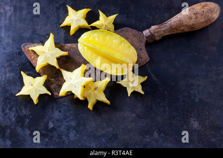 Starfruit affettato su un vecchio cleaver Foto Stock