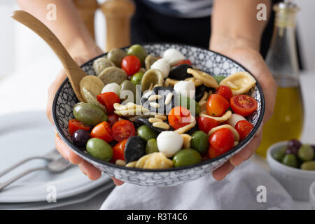 La donna che mostra mediterraneo orecchiette con pomodoro, olive e mozzarella Foto Stock