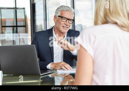 Imprenditore snd donna seduta in ufficio, discutendo di progetto Foto Stock