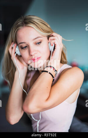 Giovane donna bionda ascolto di musica con cuffie Foto Stock