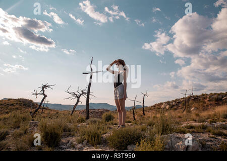 Giovane donna in campagna guardando fuori Foto Stock