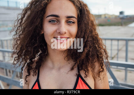 Ritratto di sorridere bruna giovane donna all'aperto Foto Stock