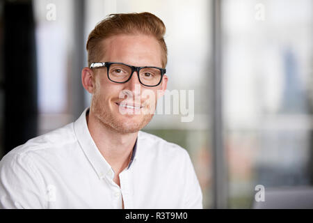 Ritratto di sorridente imprenditore redheaded indossando occhiali Foto Stock