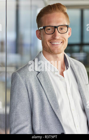 Ritratto di sorridente imprenditore redheaded indossando occhiali Foto Stock