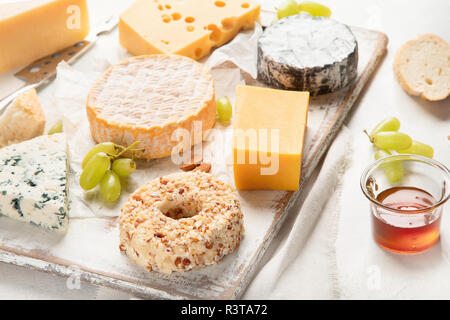 Diversi tipi di formaggi con miele, frutta e noci Foto Stock