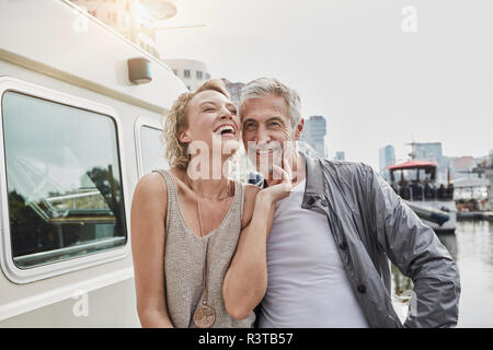 Felice l'uomo vecchio e giovane donna sul molo vicino al yacht Foto Stock