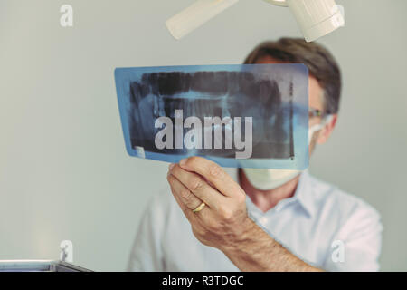 Dentista guardando immagine a raggi x prima del trattamento Foto Stock